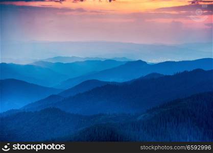 Sunset in the mountains with hills and dramatic colorful sky