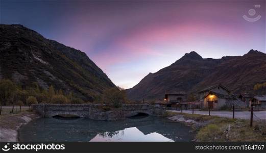 Sunset in the mountains with reflection on pond in the Alps