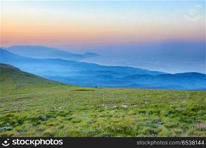 Sunset in the mountains with rocks and green grass. Sunset in the mountains