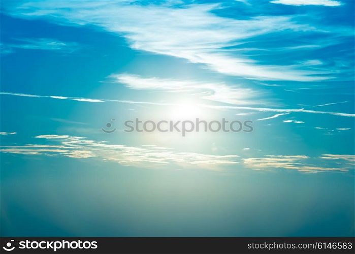 Sunset in the sky with blue marine clouds and big shining sun