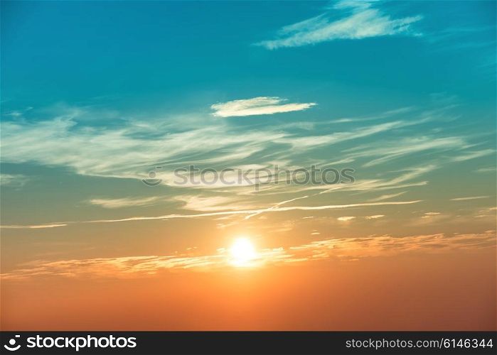 Sunset in the sky with blue orange clouds and big sun
