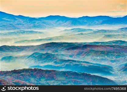 Sunset landscape in beautiful blue mountains and mist hills