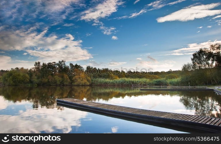 Sunset landscape over calm lake with reflections in water