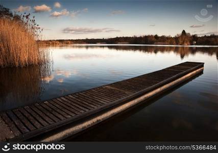 Sunset landscape over calm lake with reflections in water