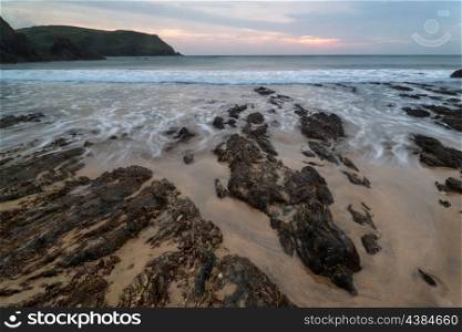 Sunset landscape seascape of rocky coastline at Hope Cove in England