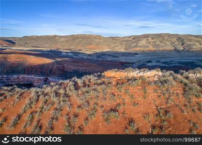 sunset light over foothills of Rocky Mountains in northern Colorado with red sandstone and canyons, aerial view