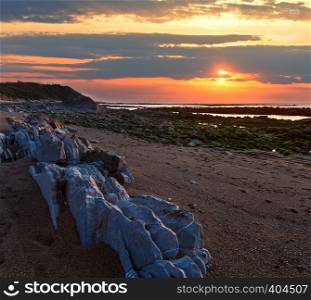 Sunset ocean coast view from beach with big picturesque stones (near Saint-Jean-de-Luz, France, Bay of Biscay).