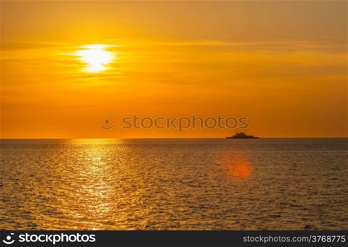 sunset on sea with ferry in distance