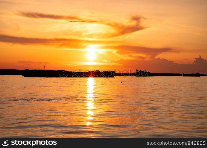 Sunset on the embankment of the Amur river in Khabarovsk. The sun set over the horizon. The embankment is lit by lanterns.. Sunset on the Amur river embankment in Khabarovsk, Russia.