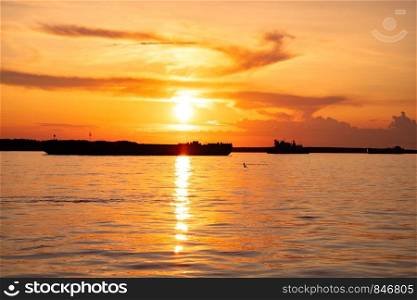Sunset on the embankment of the Amur river in Khabarovsk. The sun set over the horizon. The embankment is lit by lanterns.. Sunset on the Amur river embankment in Khabarovsk, Russia.