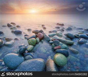 Sunset on the sea stones shore. Beautiful seascape nature composition.
