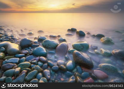 Sunset on the sea stones shore. Beautiful seascape nature composition.
