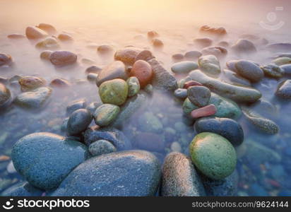 Sunset on the sea stones shore. Beautiful seascape nature composition.