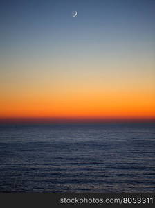 sunset on the sea with new moon