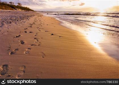 sunset on the seashore, footprints in the sand, sandy beach. footprints in the sand, sandy beach, sunset on the seashore