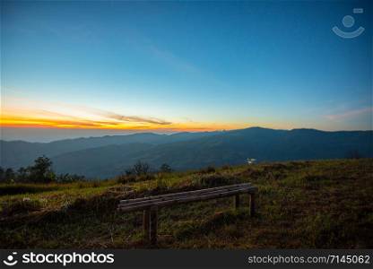 Sunset or sunrise on viewpoint hill mountain yellow and blue sky and bamboo bench