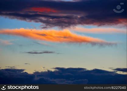 Sunset orange clouds in a blue sky at dusk