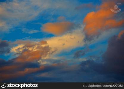 Sunset orange clouds in a blue sky at dusk