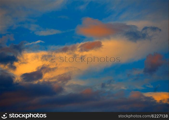 Sunset orange clouds in a blue sky at dusk