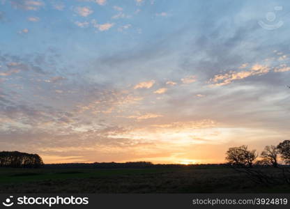 Sunset over a field in Denmark in autumn. Sunset over a field in Denmark in autumn with nordic landscape and trees