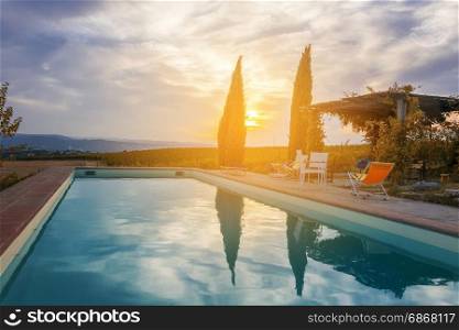 sunset over a pool in italian countryside