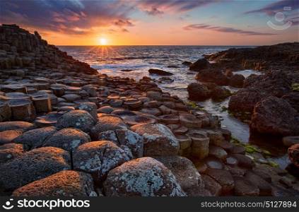 sunset over basalt columns Giant&rsquo;s Causeway, County Antrim, Northern Ireland. sunset over basalt columns Giant&rsquo;s Causeway known as UNESCO World Heritage Site, County Antrim, Northern Ireland