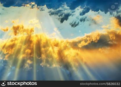 Sunset over beautiful blue sky with sun shining through clouds