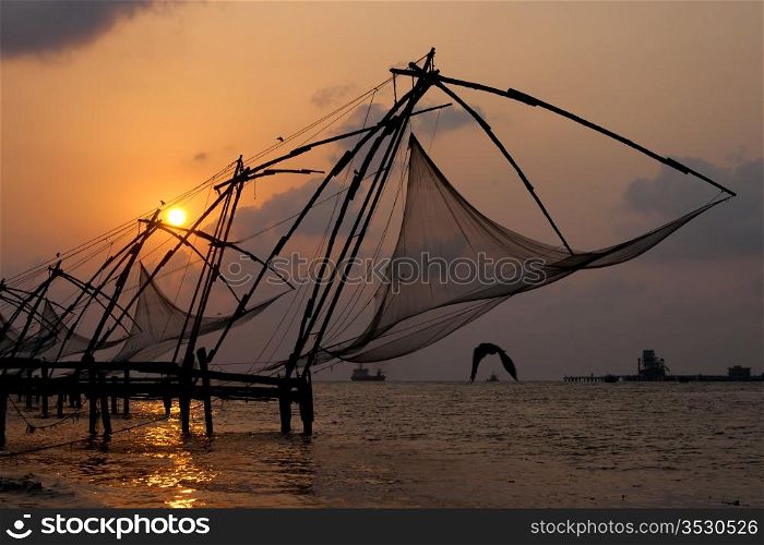 Sunset over Chinese Fishing nets and boat in Cochin (Kochi), Kerala, India.