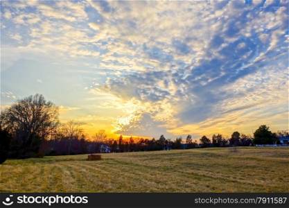 sunset over farm field landscape