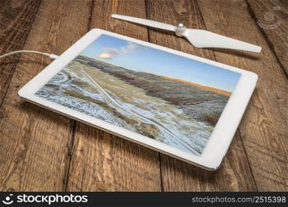 sunset over foothills of Rocky Mountains in northern Colorado, fall or winter scenery, reviewing an aerial image on a digital tablet
