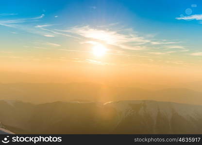 Sunset over hills and mountains with snow