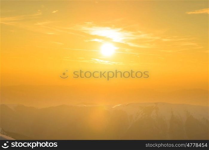 Sunset over hills and mountains with snow