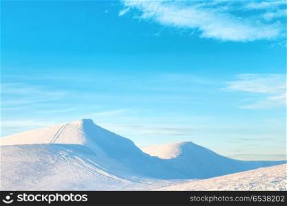 Sunset over hills with snow. Mountains in snow. Landscape with sunset over hills