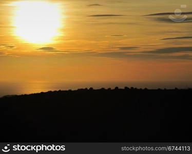 Sunset over mediterranean sea. Sunset over the mediterranean sea with coastal hill in foreground