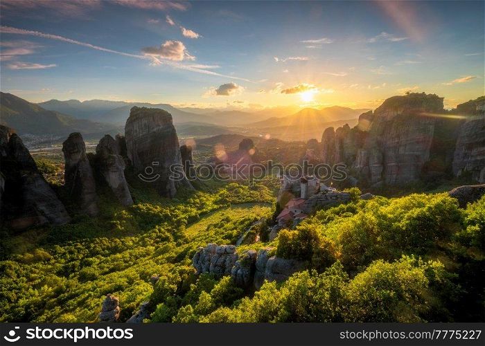 Sunset over monastery of Rousanou and Monastery of St. Nicholas Anapavsa in famous greek tourist destination Meteora in Greece on sunset with sun rays and lens flare. Sunset over monasteries of Meteora