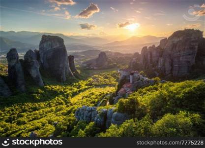 Sunset over monastery of Rousanou and Monastery of St. Nicholas Anapavsa in famous greek tourist destination Meteora in Greece on sunset with sun rays and lens flare. Sunset over monasteries of Meteora