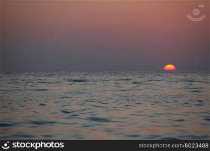 Sunset over sea. Beautifulk round sun at sunset time over sea