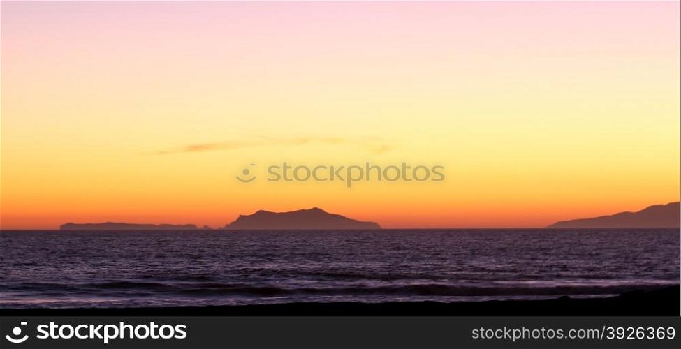 Sunset over the Anacapa island with ocean in the foreground.
