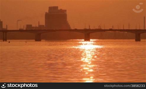 sunset over the bridge across great river