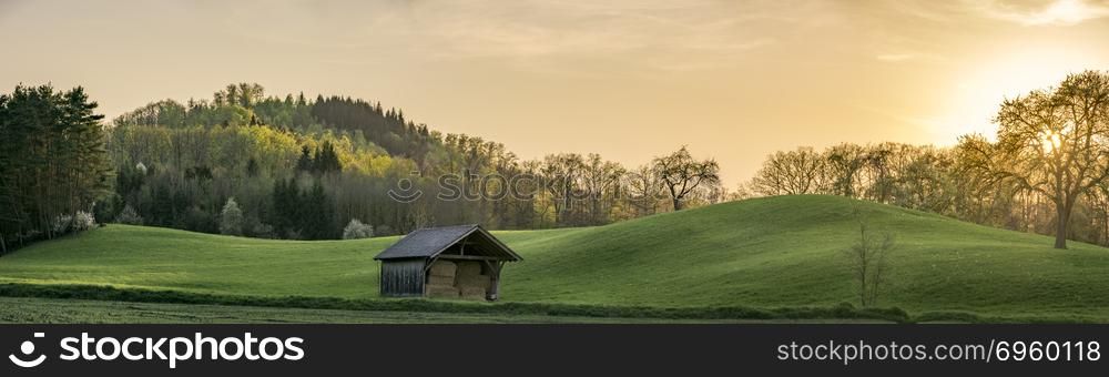 Sunset panorama with green hills in Germany. Panorama at sunset with green hills and forest under a golden sky, near the german town Schwabisch Hall, SouthWest Germany