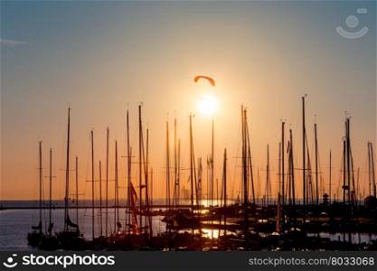 Sunset paragliding over yachts silhouette and sun sea