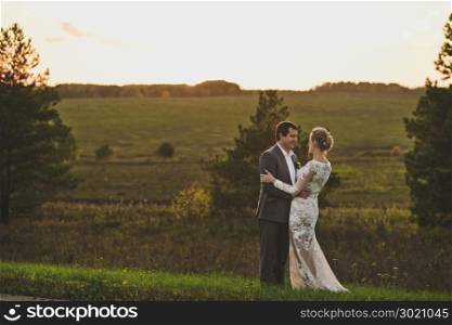 Sunset photo of a young couple in love.. Evening photo of the newlyweds on the background of endless fields 228