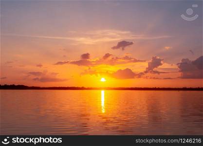 Sunset reflection lagoon. beautiful sunset behind the clouds and blue sky above the over lagoon landscape background. dramatic sky with cloud at sunset