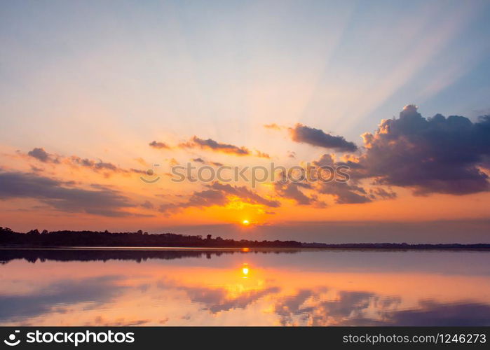 Sunset reflection lagoon. beautiful sunset behind the clouds and blue sky above the over lagoon landscape background. dramatic sky with cloud at sunset