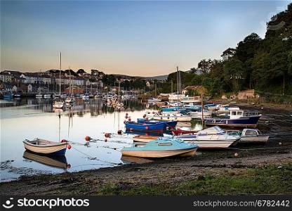 Sunset reflections of boats in harbour in Summer