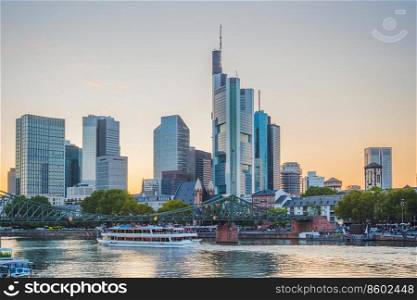 Sunset sky over city embankment, touristic boats and bridge by Frankfurt-am-Main skyline with modern architecture, Germany