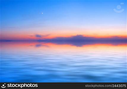 Sunset sky panorama with a young moon above the water surface. Sunset sky panorama with young moon above water surface
