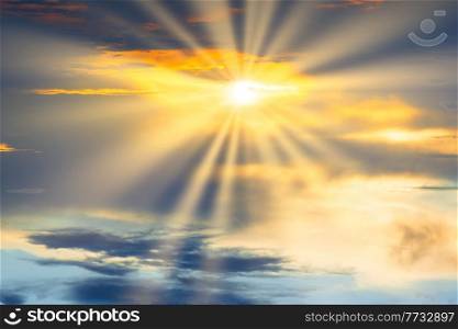 Sunset sky with dramatic clouds and sun shining through cloud. Holy heaven sky landscape