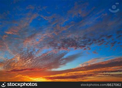 Sunset sky with orange clouds over blue background