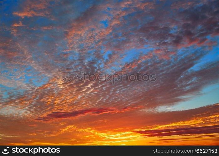 Sunset sky with orange clouds over blue background